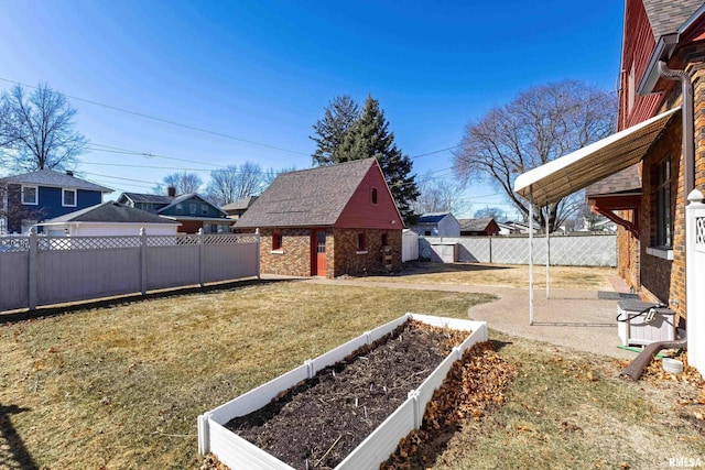 view of yard with a garden, a fenced backyard, and an outdoor structure