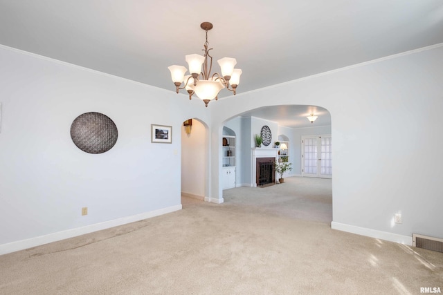 carpeted empty room featuring a fireplace with flush hearth, arched walkways, visible vents, and baseboards