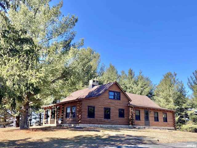 log cabin with a chimney and log siding