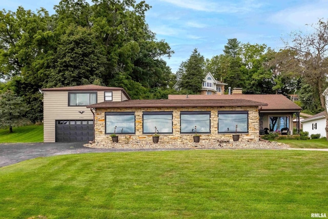 view of front of property featuring a garage, stone siding, aphalt driveway, and a front yard