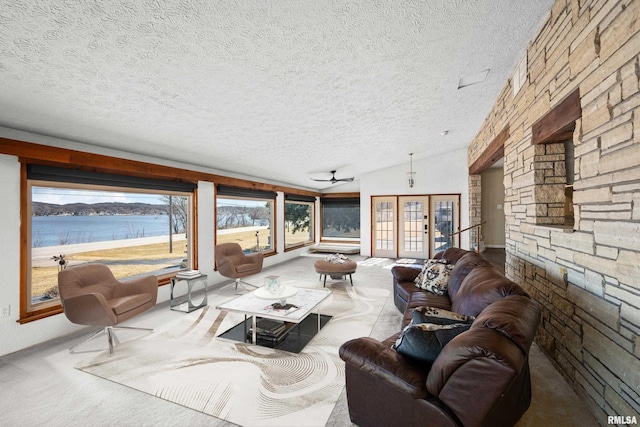 carpeted living room featuring french doors, a water view, vaulted ceiling, and a textured ceiling