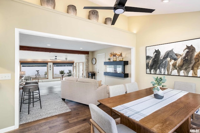 dining space with dark wood-style floors, vaulted ceiling with beams, a ceiling fan, and baseboards