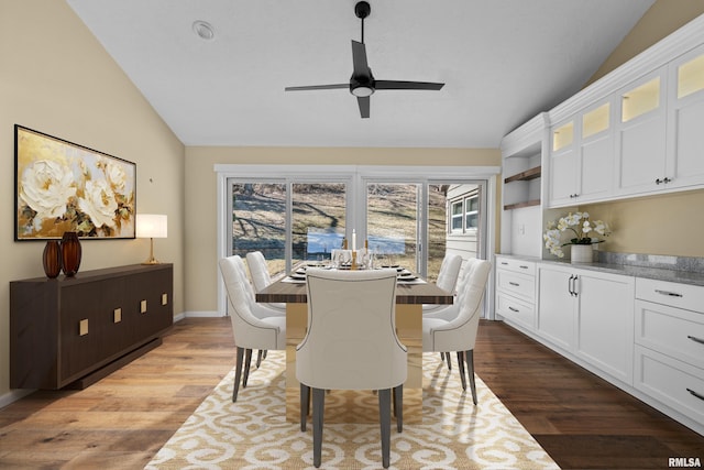 dining area featuring lofted ceiling, ceiling fan, baseboards, and wood finished floors