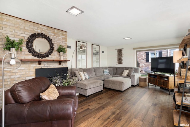 living room featuring dark wood-type flooring and a brick fireplace