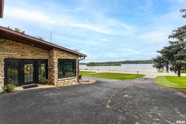 view of yard featuring a water view and french doors