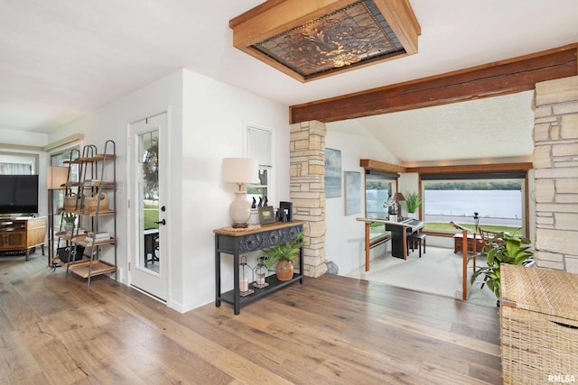 hall featuring vaulted ceiling with beams and wood finished floors