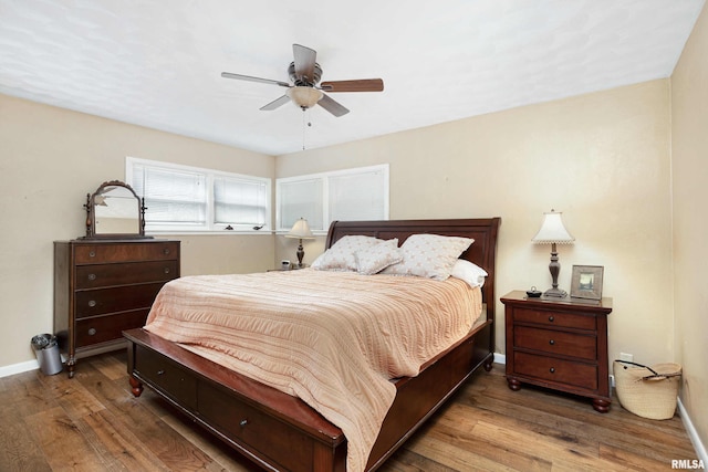 bedroom featuring wood finished floors, a ceiling fan, and baseboards