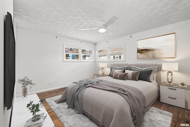 bedroom featuring ceiling fan, a textured ceiling, baseboards, and wood finished floors