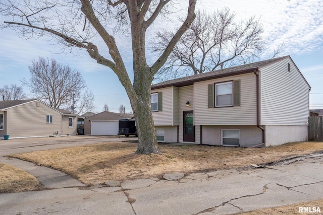 split foyer home featuring a garage and an outbuilding