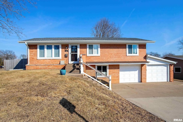 single story home featuring an attached garage, brick siding, fence, concrete driveway, and a front yard