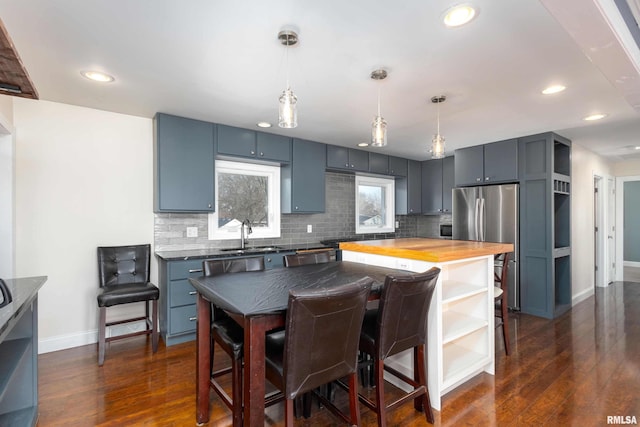 kitchen featuring dark wood finished floors, decorative backsplash, wood counters, open shelves, and a sink