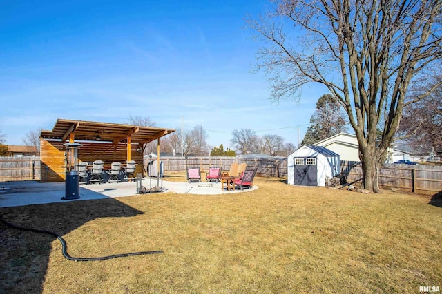 view of yard featuring a storage shed, a patio area, a fenced backyard, and an outdoor structure