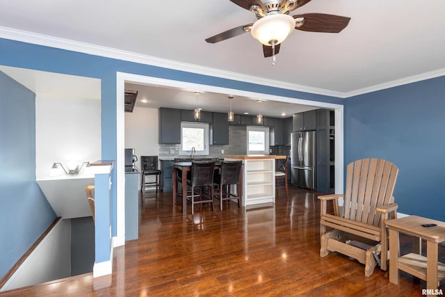 dining space featuring ceiling fan, dark wood finished floors, and crown molding