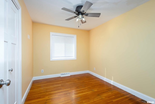 unfurnished room featuring ceiling fan, wood finished floors, visible vents, and baseboards