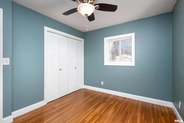 unfurnished bedroom featuring baseboards, a closet, and wood finished floors