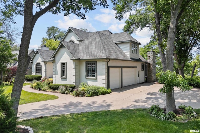 2 S Shore Ln, Rapids City, IL 61278 - view of front of house featuring stucco siding, concrete driveway, a chimney, and an attached garage