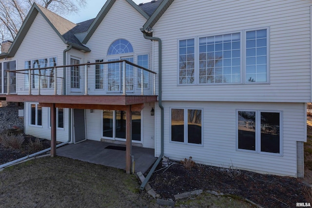 back of house with a deck and a patio area