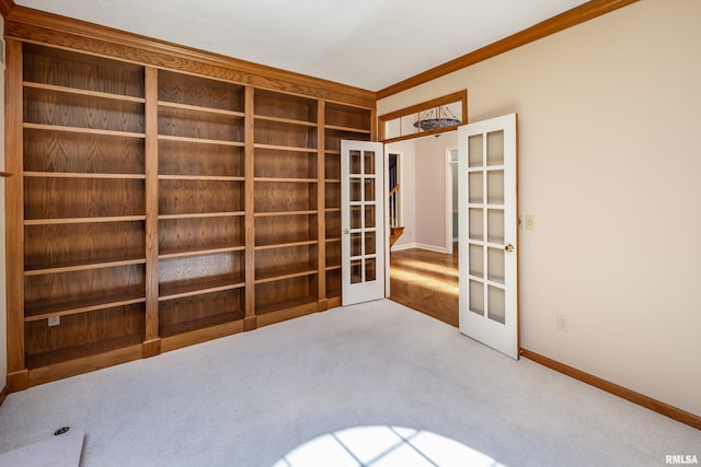 empty room featuring french doors, carpet flooring, and baseboards