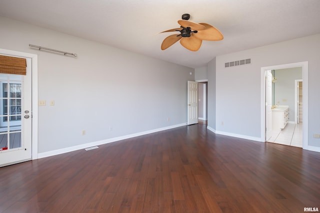 empty room featuring ceiling fan, visible vents, and wood finished floors