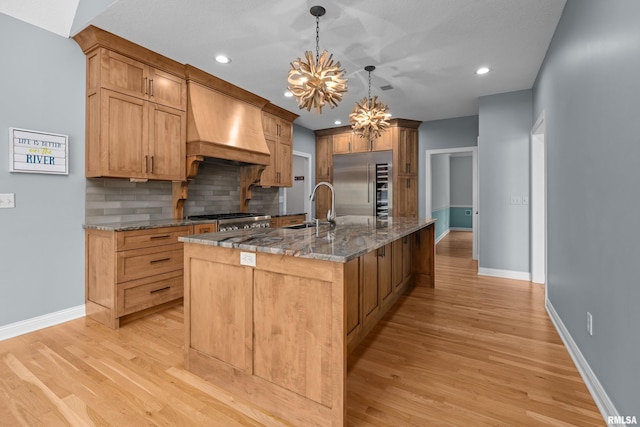 2 S Shore Ln, Rapids City, IL 61278 - kitchen with high end fridge, custom exhaust hood, a chandelier, tasteful backsplash, and light wood-style flooring