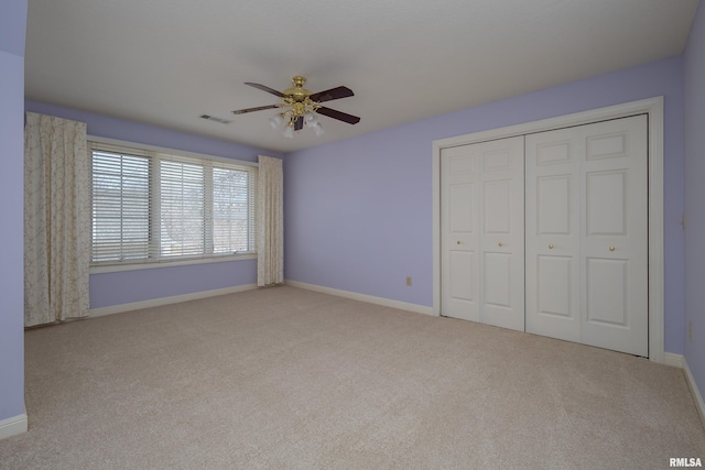 unfurnished bedroom with a closet, carpet flooring, visible vents, and baseboards