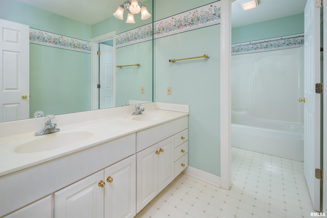 bathroom featuring double vanity, baseboards, a sink, and tile patterned floors