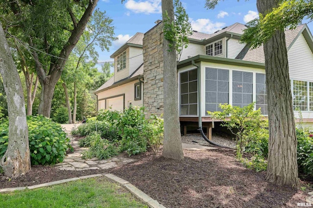 2 S Shore Ln, Rapids City, IL 61278 - view of side of home featuring a sunroom, a chimney, a garage, and a shingled roof