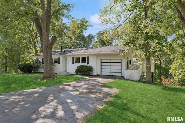 ranch-style home featuring a garage, a front lawn, and aphalt driveway