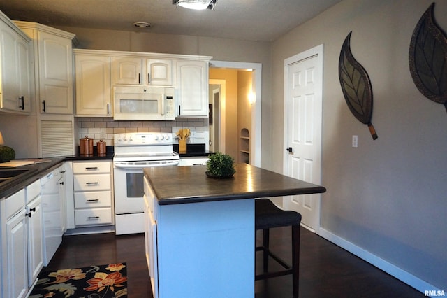 kitchen featuring a breakfast bar area, white appliances, dark wood-style flooring, a kitchen island, and backsplash