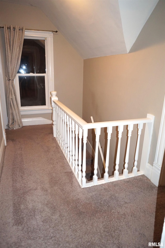 hall featuring lofted ceiling, carpet, and an upstairs landing