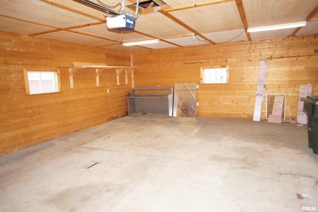 garage featuring a garage door opener and wooden walls