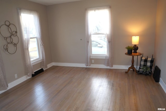 unfurnished room with baseboards and wood finished floors