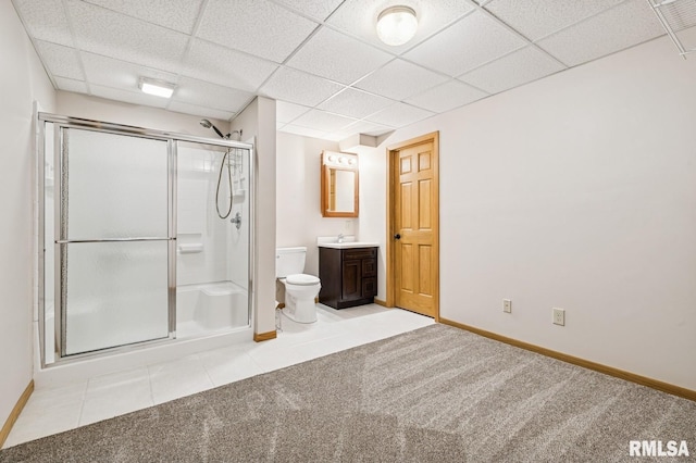 bathroom featuring toilet, a paneled ceiling, a shower stall, and vanity