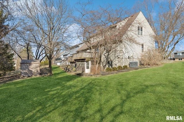 exterior space featuring an outbuilding, a yard, and a wooden deck