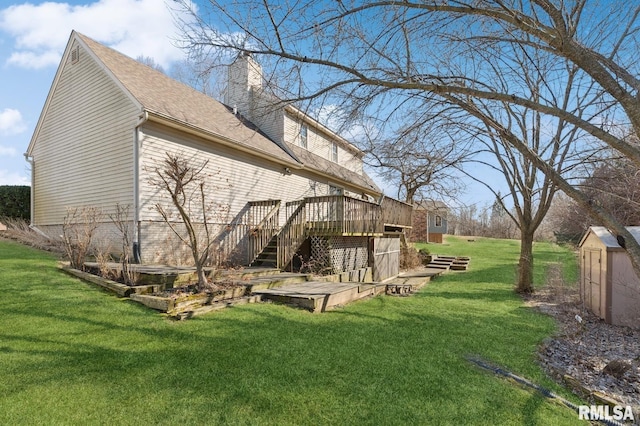 back of property with a yard, a chimney, a storage shed, a deck, and an outdoor structure