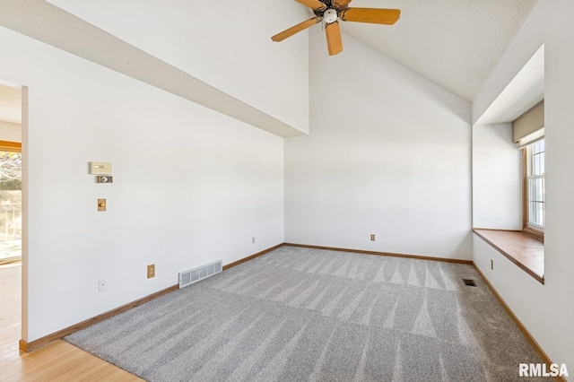 spare room featuring high vaulted ceiling, visible vents, and baseboards