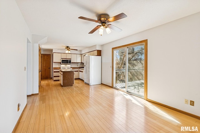 unfurnished living room with light wood-style floors, baseboards, and a ceiling fan