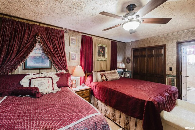 bedroom with carpet floors, ensuite bathroom, ceiling fan, a textured ceiling, and wallpapered walls