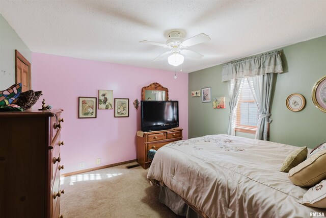 bedroom featuring light carpet, ceiling fan, a textured ceiling, and baseboards