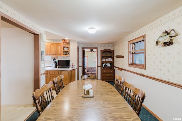 dining room featuring wainscoting and wallpapered walls