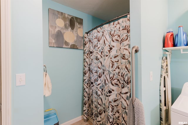 full bath featuring washer / clothes dryer and curtained shower