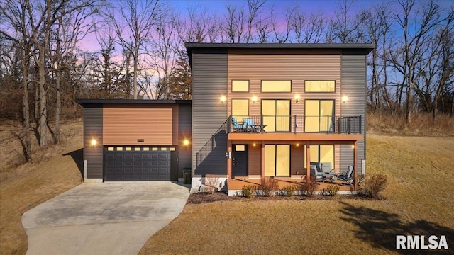 modern home featuring concrete driveway and a balcony