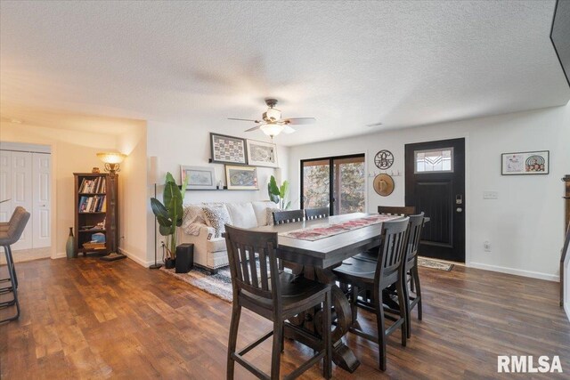 dining room featuring a textured ceiling, ceiling fan, dark wood-style flooring, and baseboards