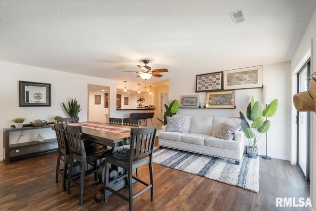 dining area featuring visible vents, a textured ceiling, and wood finished floors