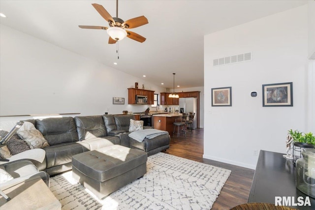 living area with visible vents, ceiling fan, dark wood-type flooring, vaulted ceiling, and recessed lighting