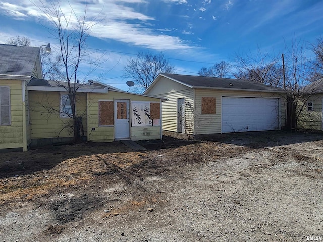 view of front of property with a garage and an outdoor structure