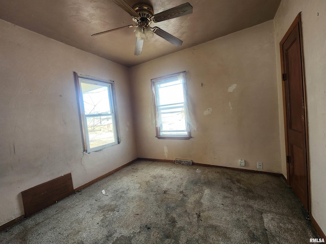 spare room with a ceiling fan, carpet, visible vents, and baseboards