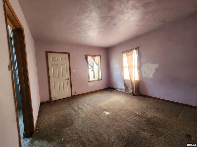 carpeted spare room featuring baseboards