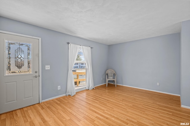 foyer entrance with light wood-type flooring and baseboards