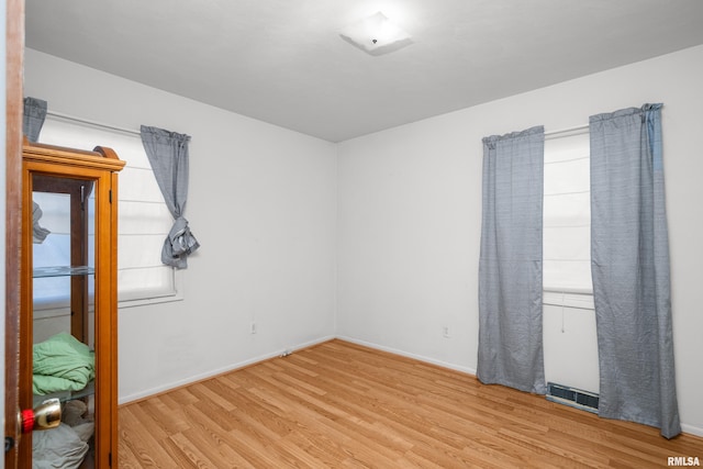 unfurnished room with baseboards, visible vents, and light wood-style floors